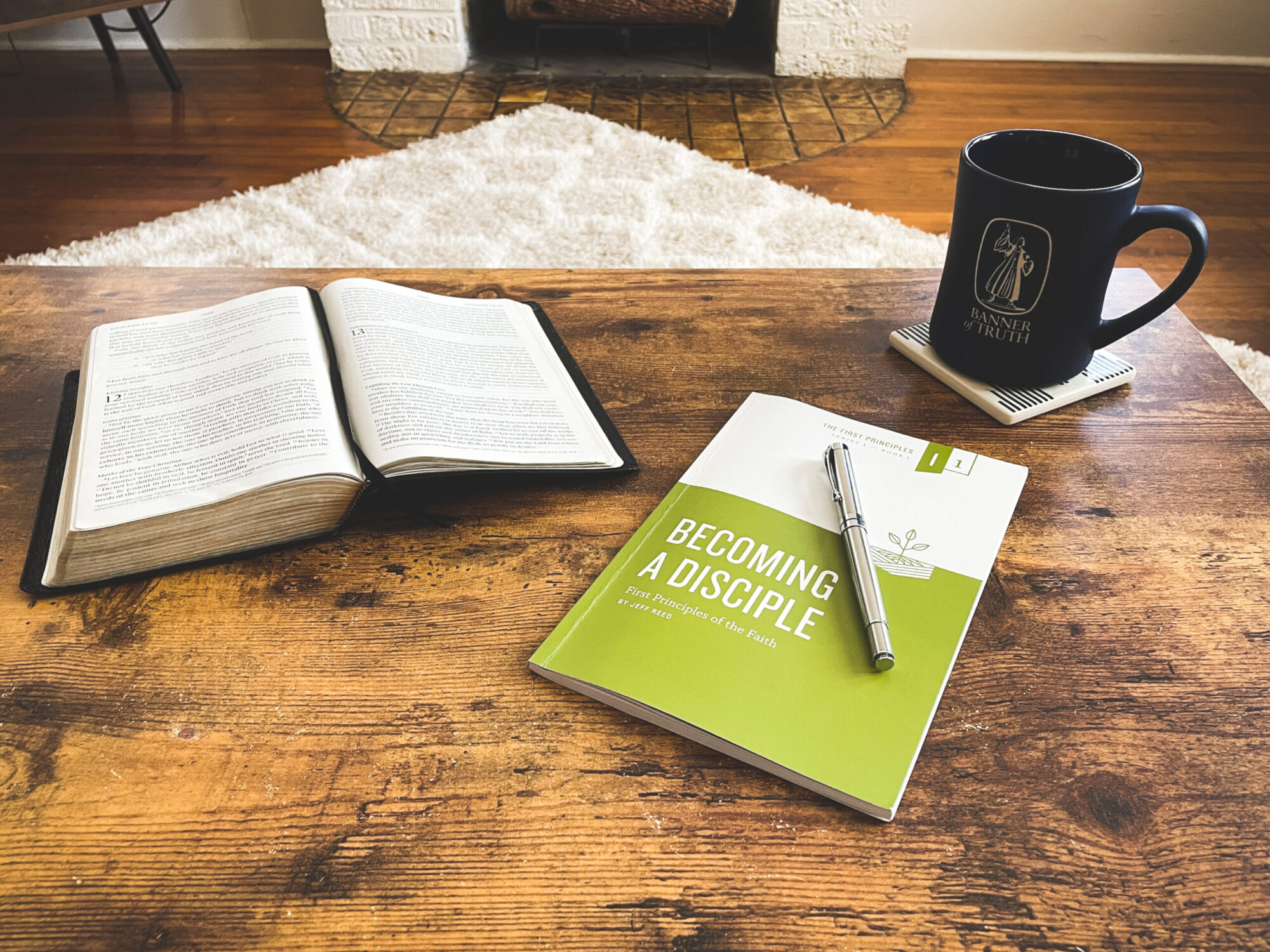 Open Bible on desk next to The First Principles Series booklet "Becoming a Disciple"