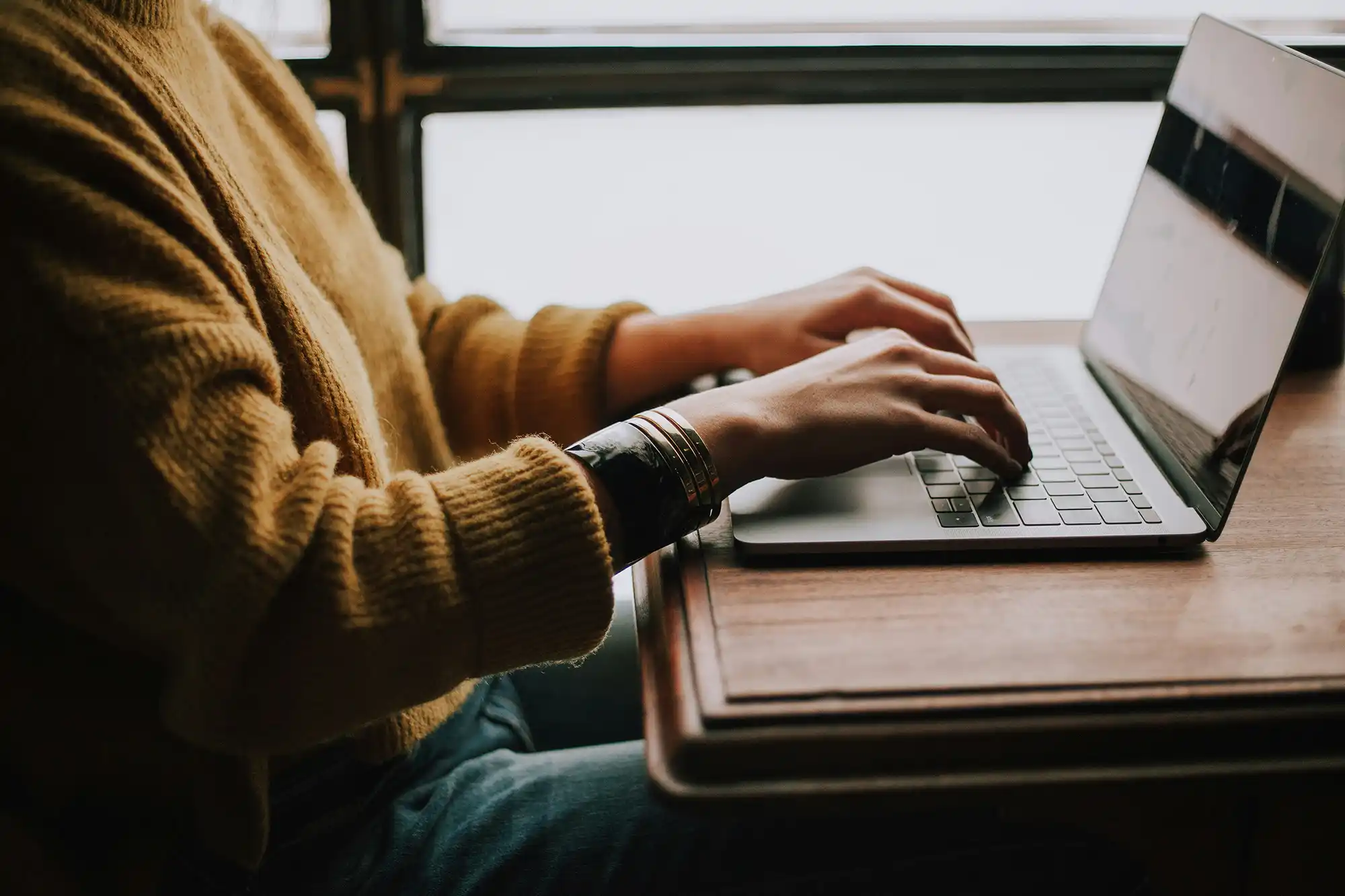 closeup of hands typing on computer keyboard