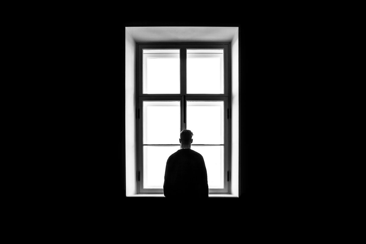 Silhouette of person looking out window