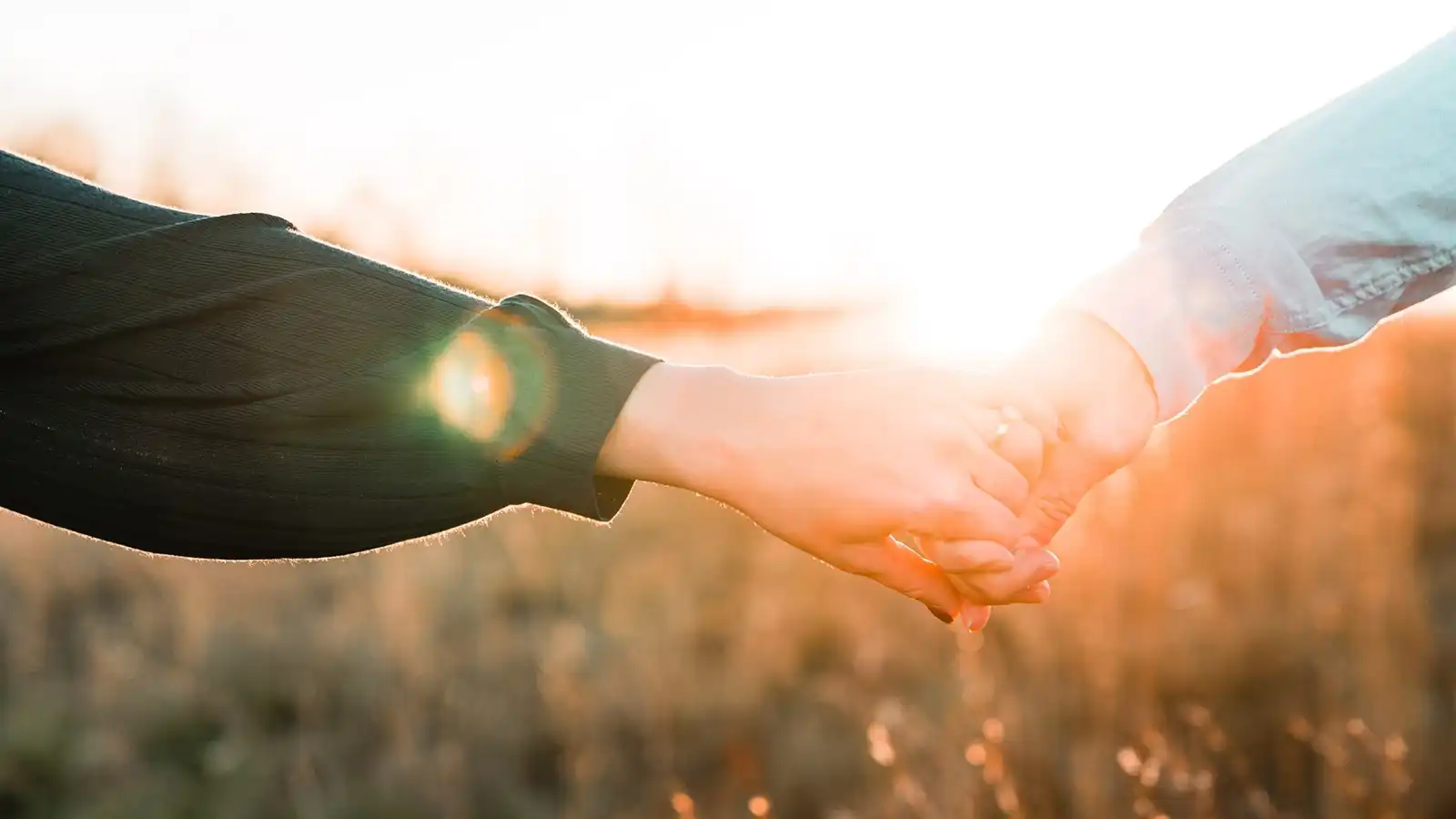 closeup of 2 persons holding hands