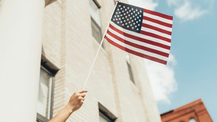 person waiving american flag