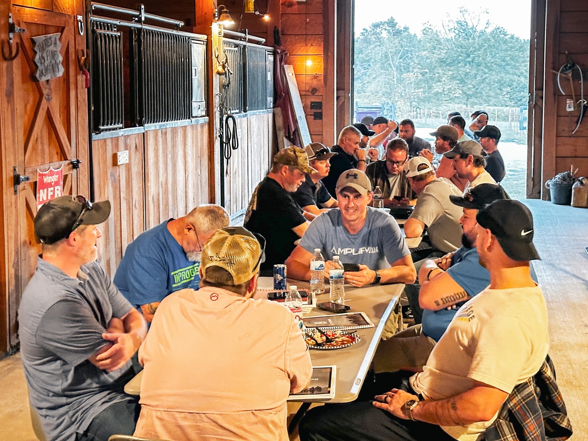 Men having dinner during BetterMan in a barn