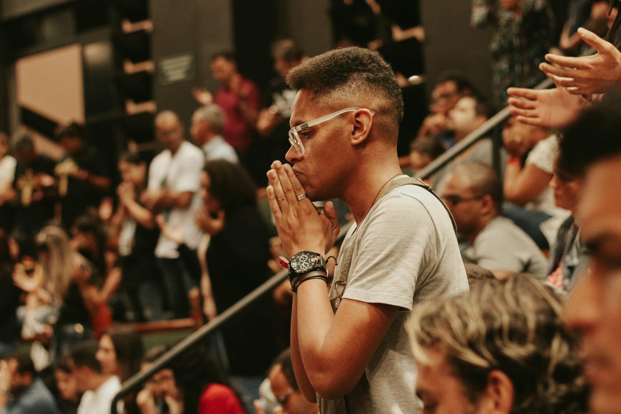 Black guy worshiping in a crowd