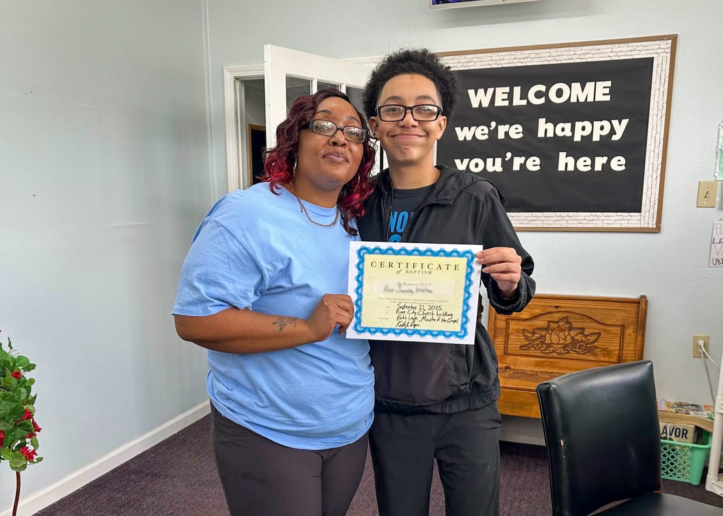 mom and son holding certificate in office