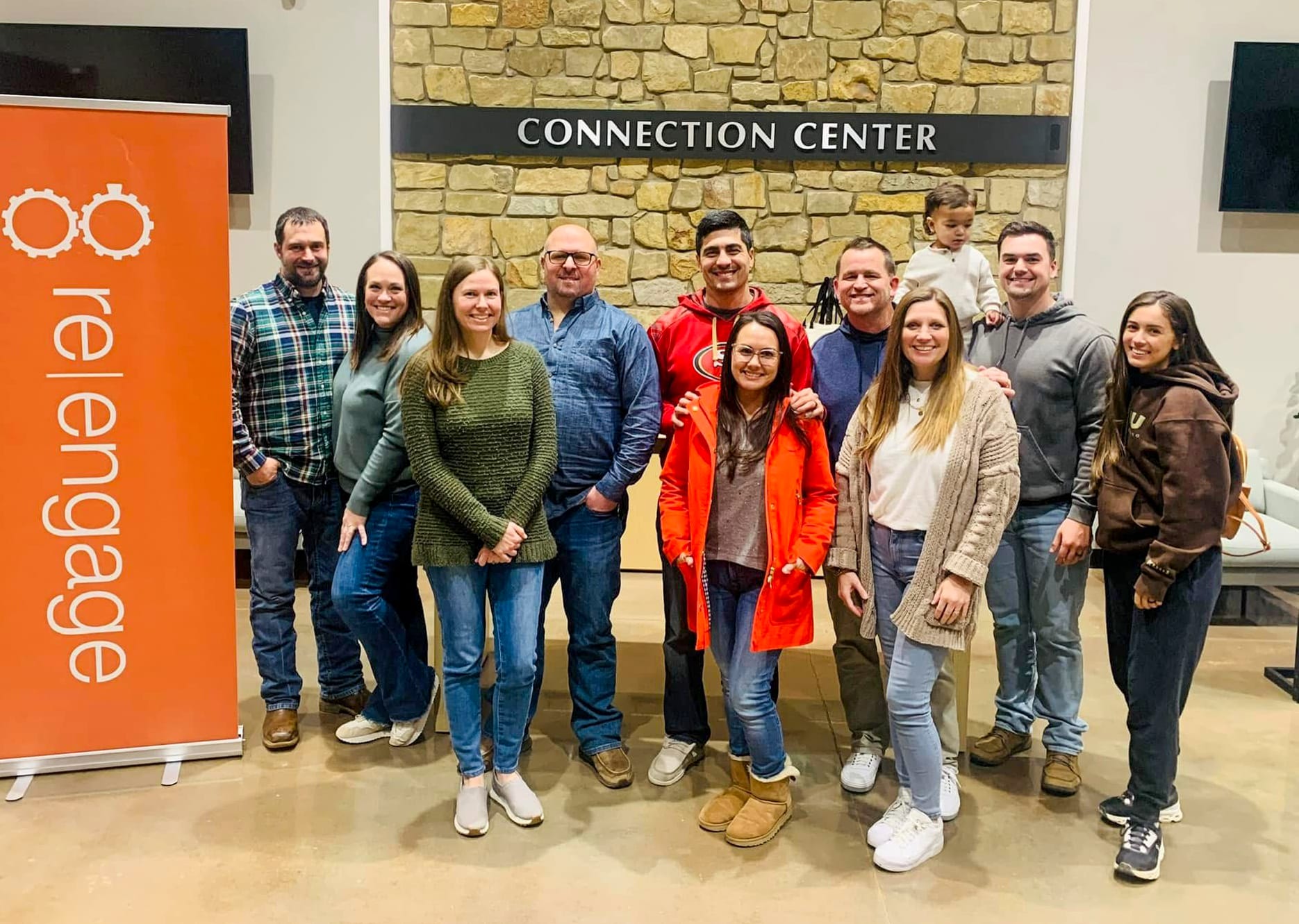 group photo in a church atrium standing next to a ReEngage banner